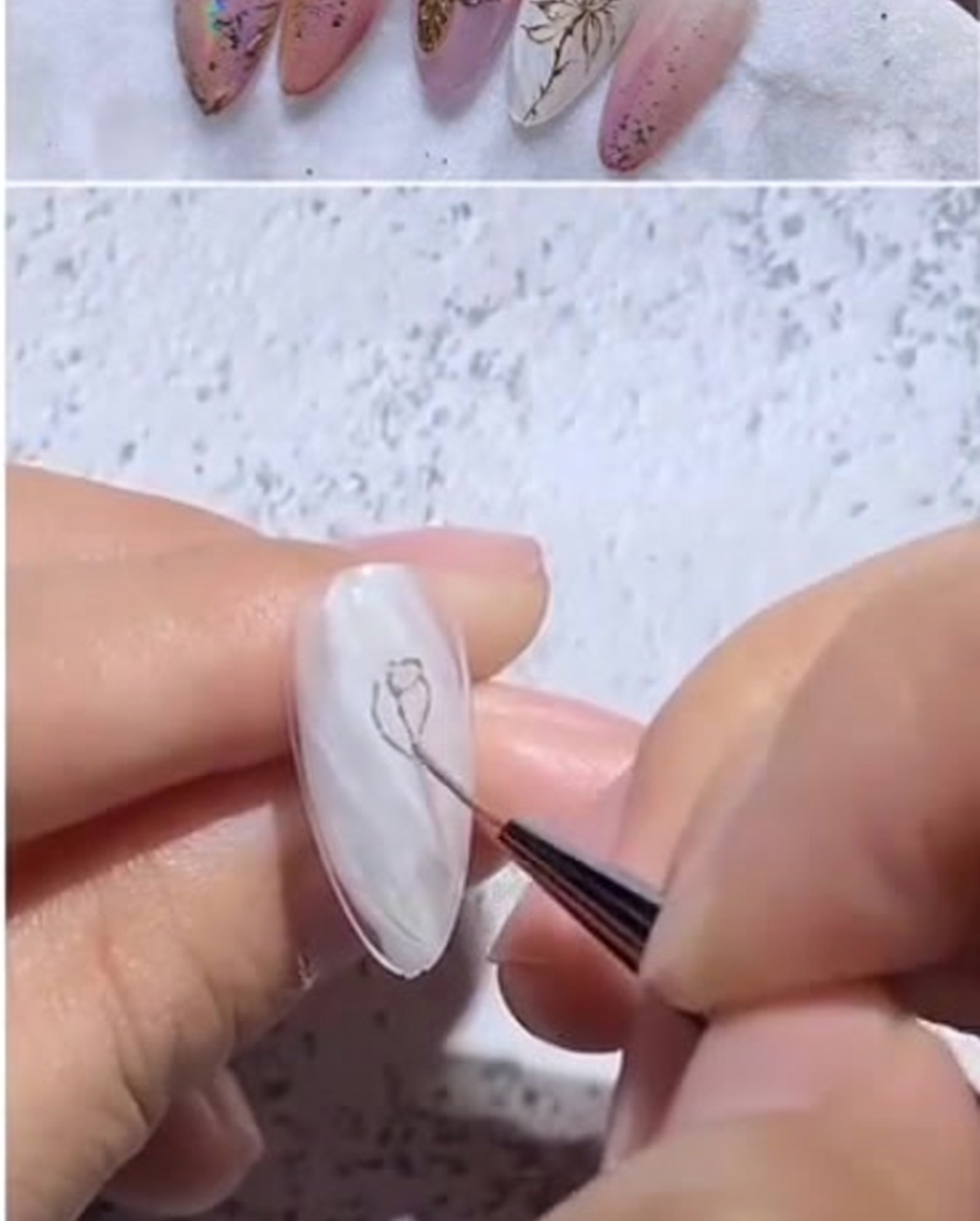 Close-up view of a fine liner brush applying gold gel to form a small, tight petal shape in the center of the nail.