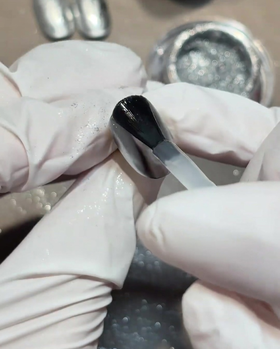 Applying a matte finish top coat over the nail.