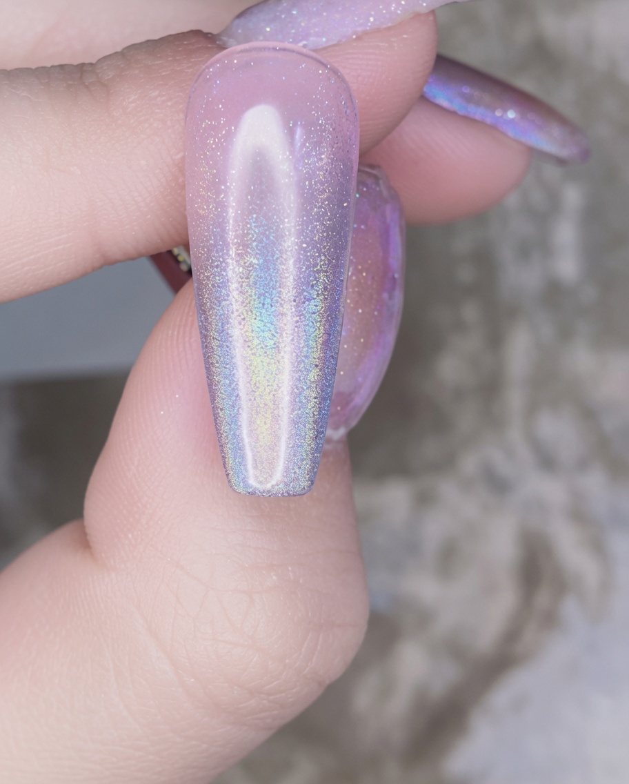 A nail brush applying a clear layer of reinforcement gel over the chrome-decorated nail.