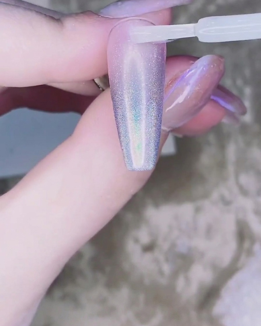 A tiny bead of clear adhesive gel placed on the center of the nail.