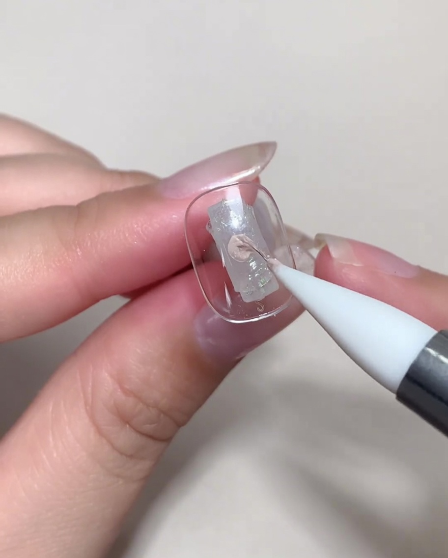 A nail tip being placed under a UV/LED lamp for curing.