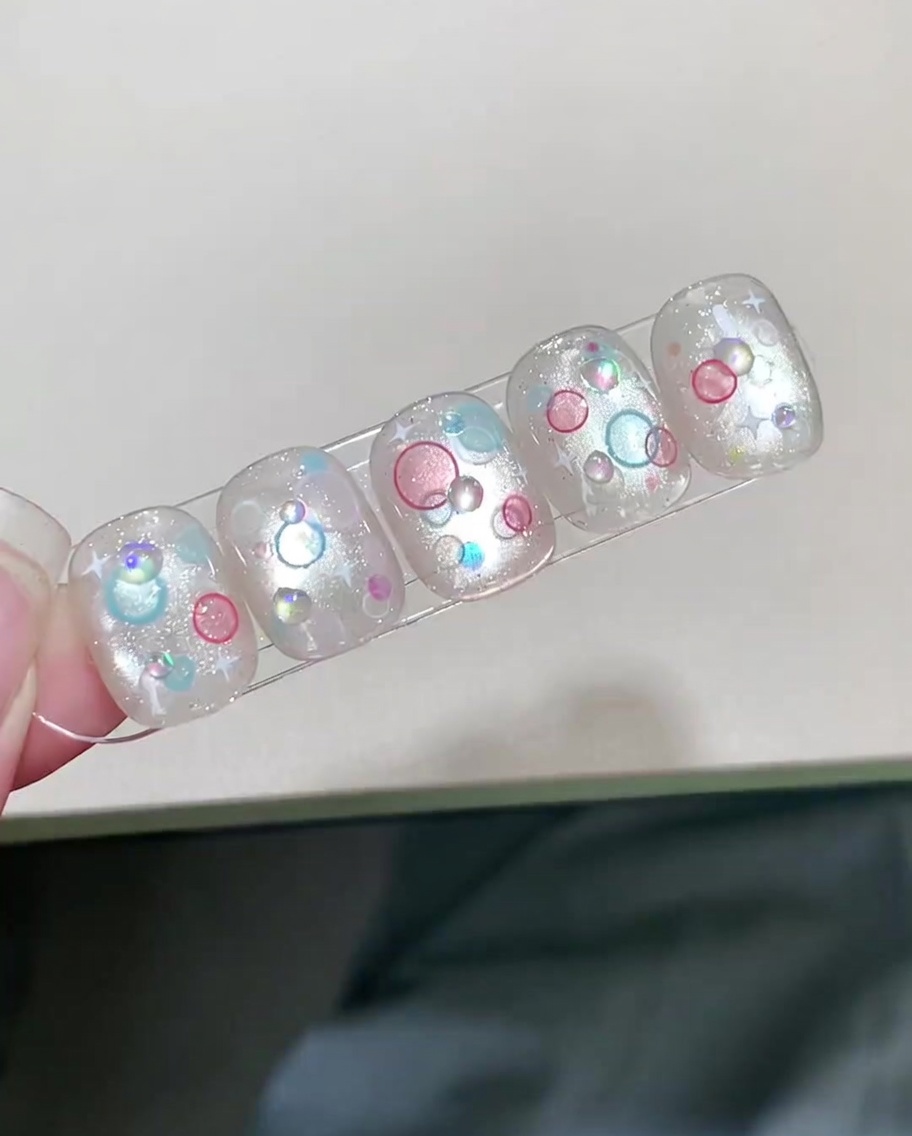 A finished nail with 3D bubble art being cured inside a UV/LED lamp.