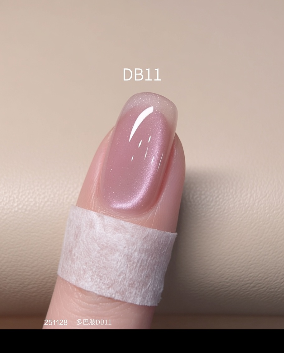 A finished, pink cat-eye effect nail undergoing its final cure under a bright UV/LED nail lamp.
