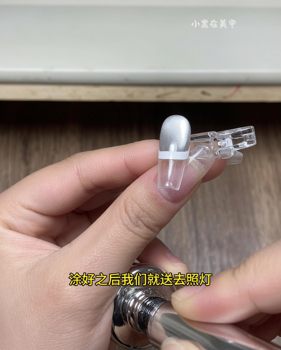A finger with a French tip sticker positioned inside a UV/LED nail lamp, with the nail tip under the light source.