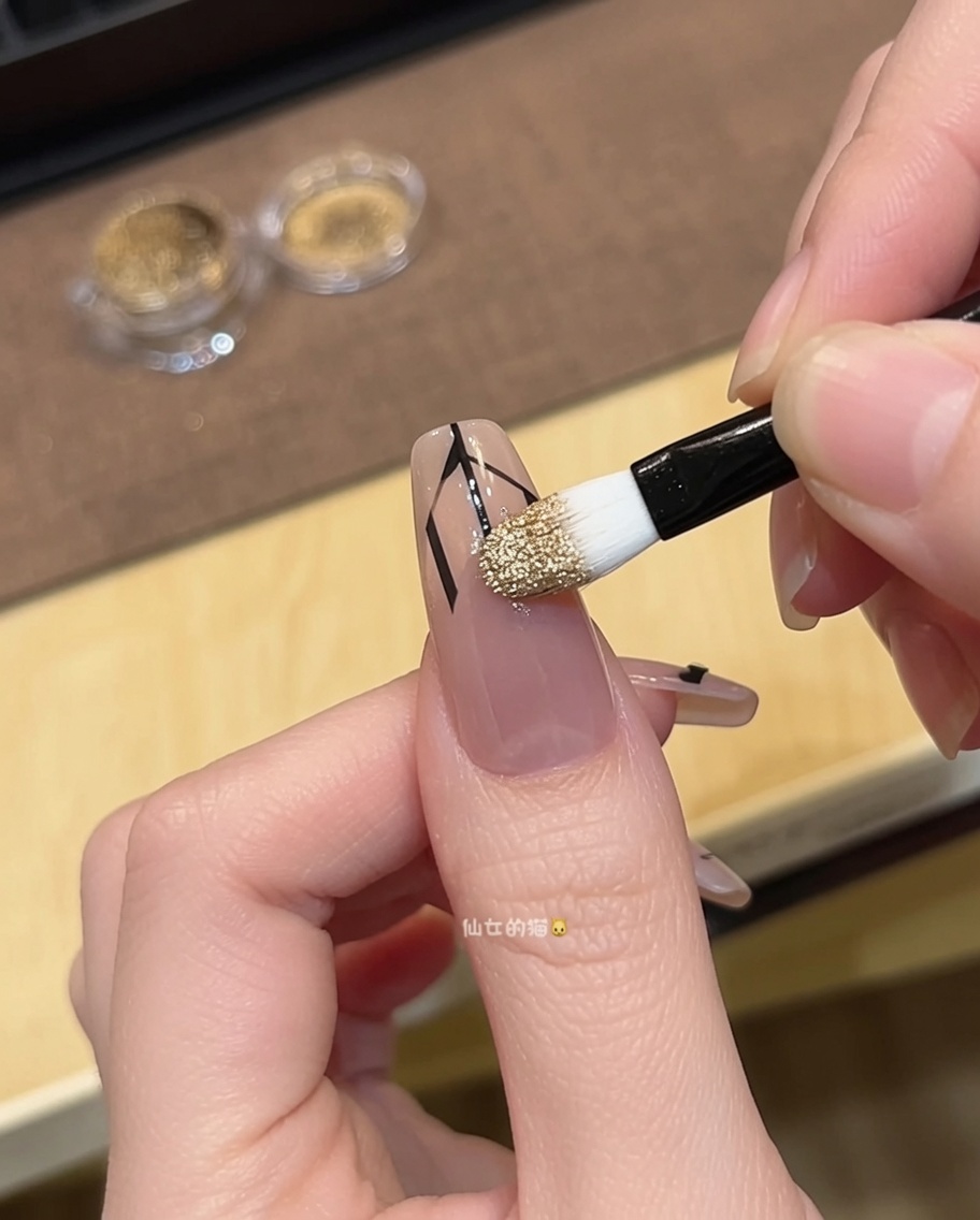 A close-up showing tweezers carefully cleaning the excess gold powder around the French tip edge.