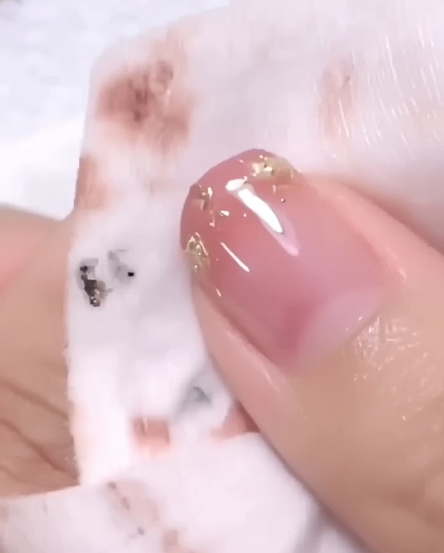 A hand placed inside a UV/LED nail lamp for the final curing process.