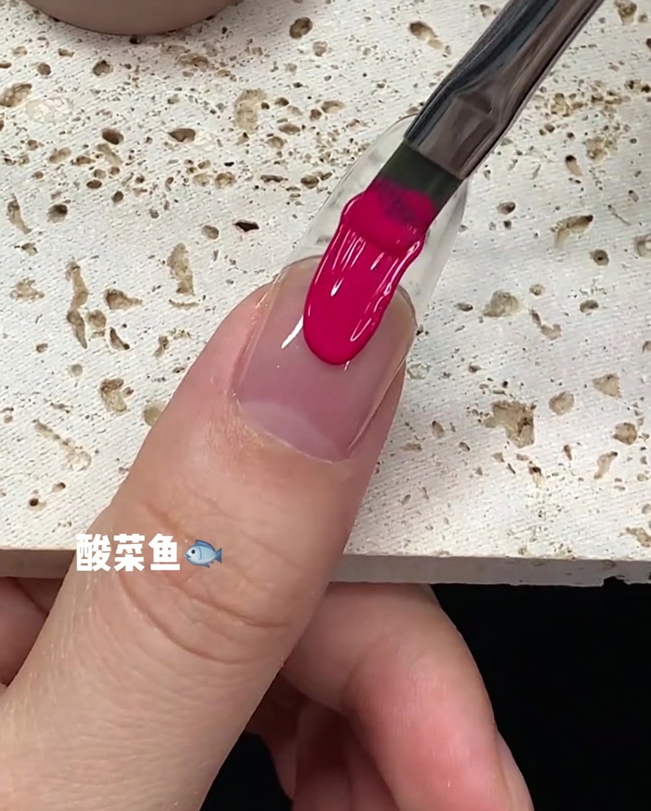 A brush stroke of bright pink gel polish running down the center of a nail plate.