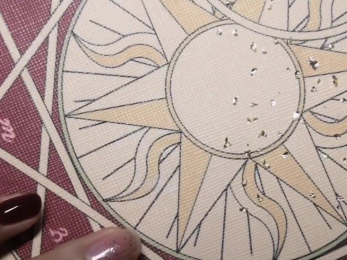A close-up view of a brush applying a thin layer of clear base coat onto a natural nail.