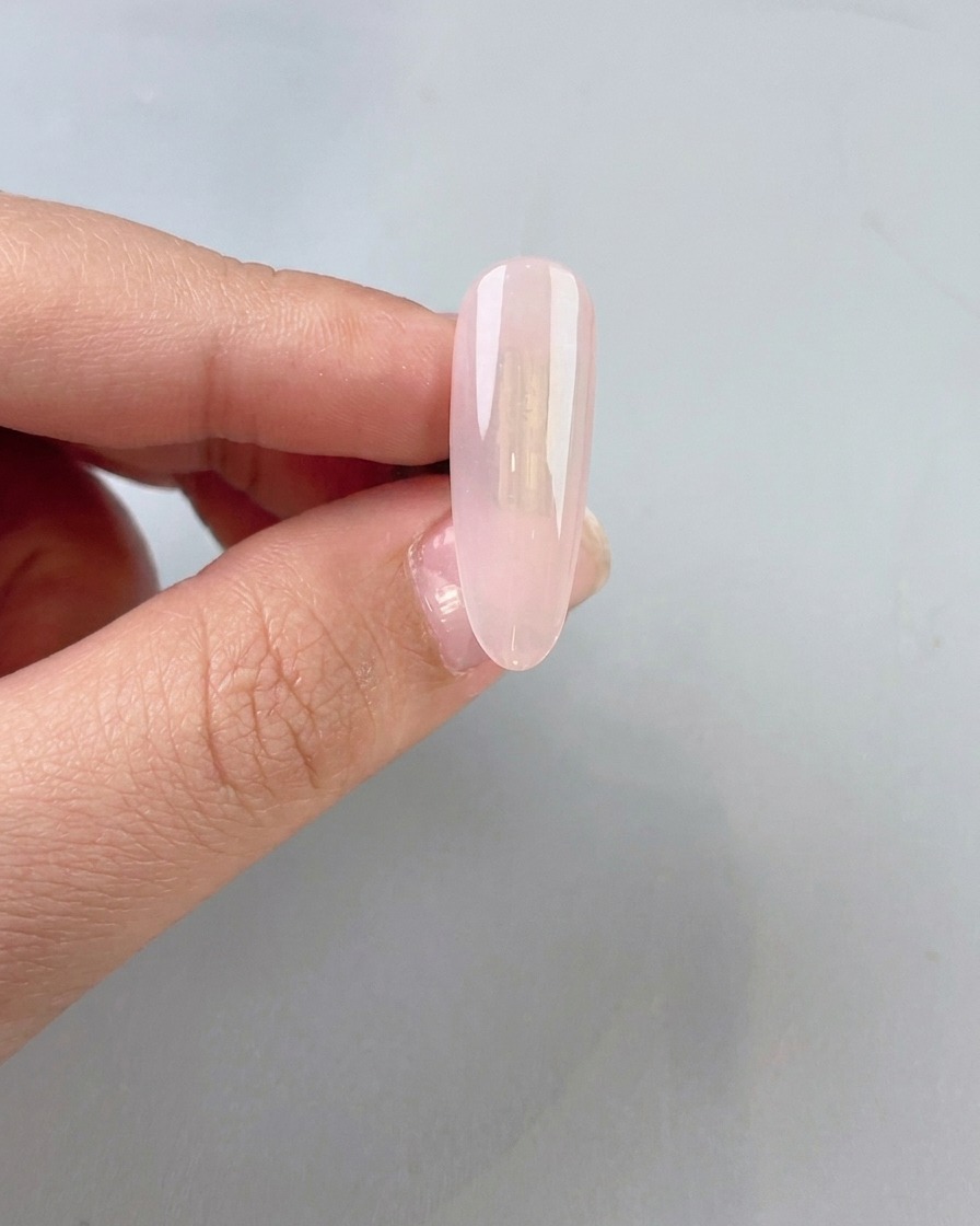 A clear, slightly milky jade gel base being applied to a natural nail.