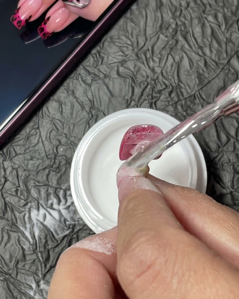 A manicured nail sitting inside a UV lamp, undergoing the curing process.