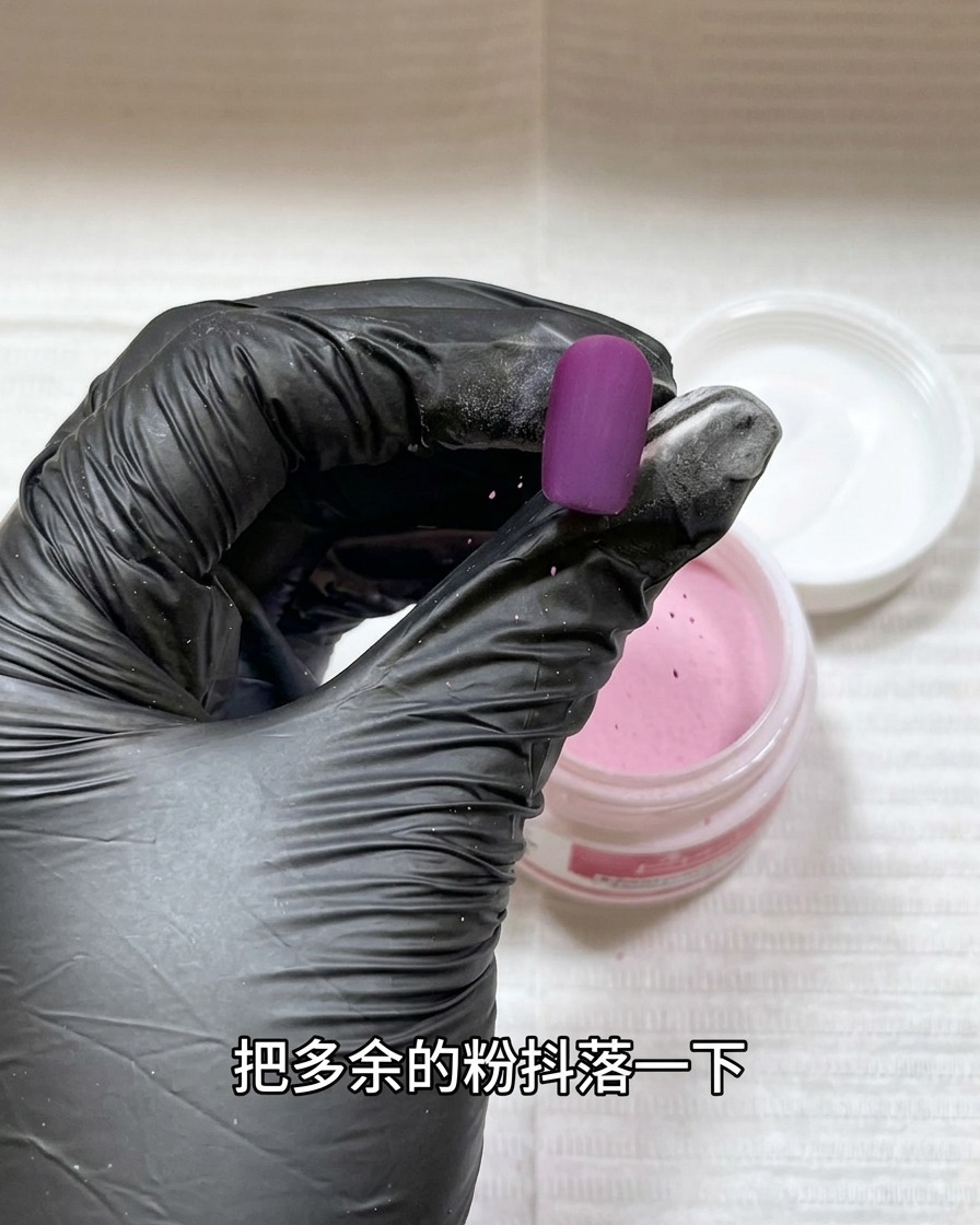 A nail tip coated in acrylic powder being held under a small handheld UV/LED lamp.