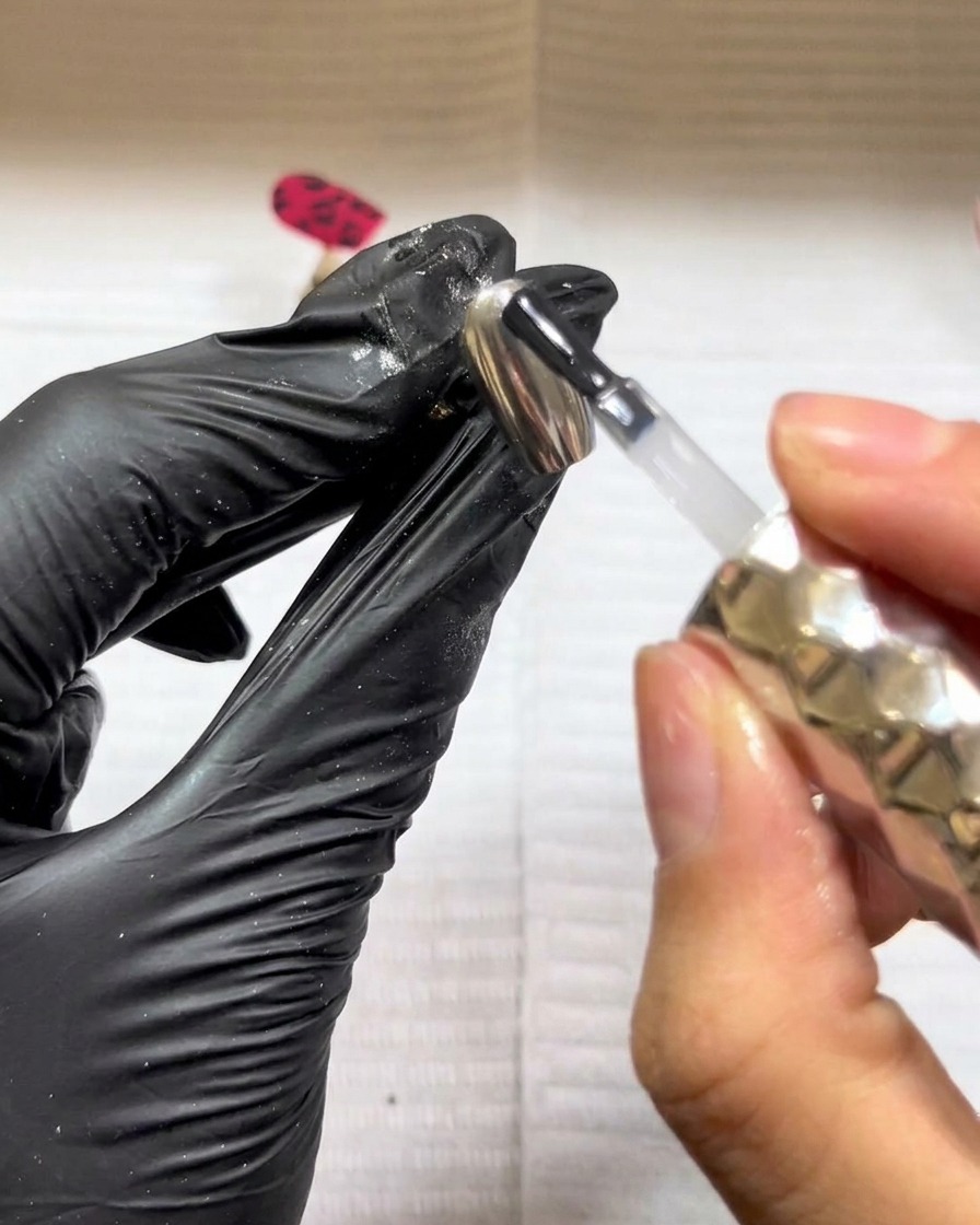 The nail with the leopard print design curing under a UV/LED lamp.