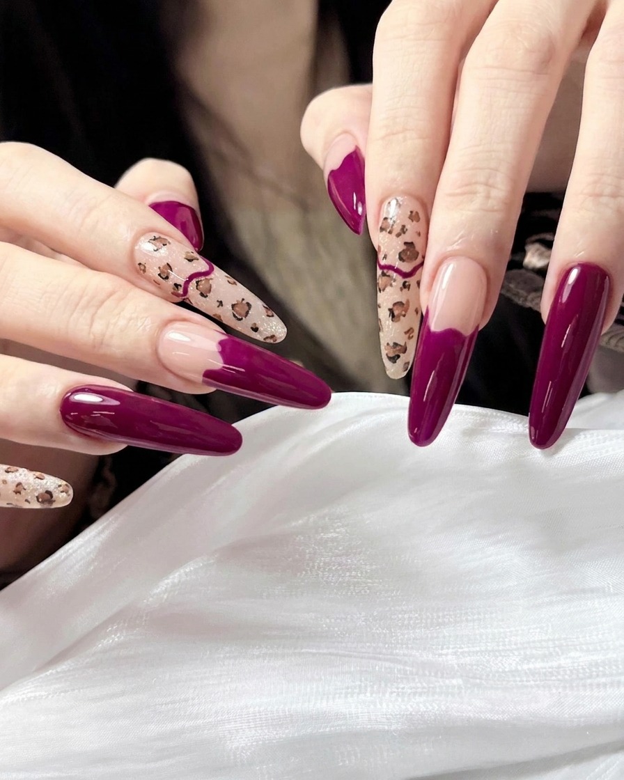 A brush applying a clear, high-gloss top coat to the finished leopard print and magenta manicure.