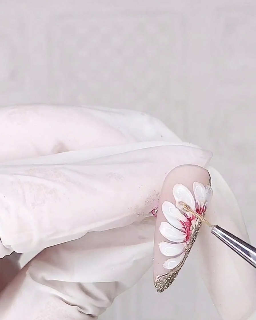 A view of the nail being placed under a UV lamp for curing the 3D adhesive gel.