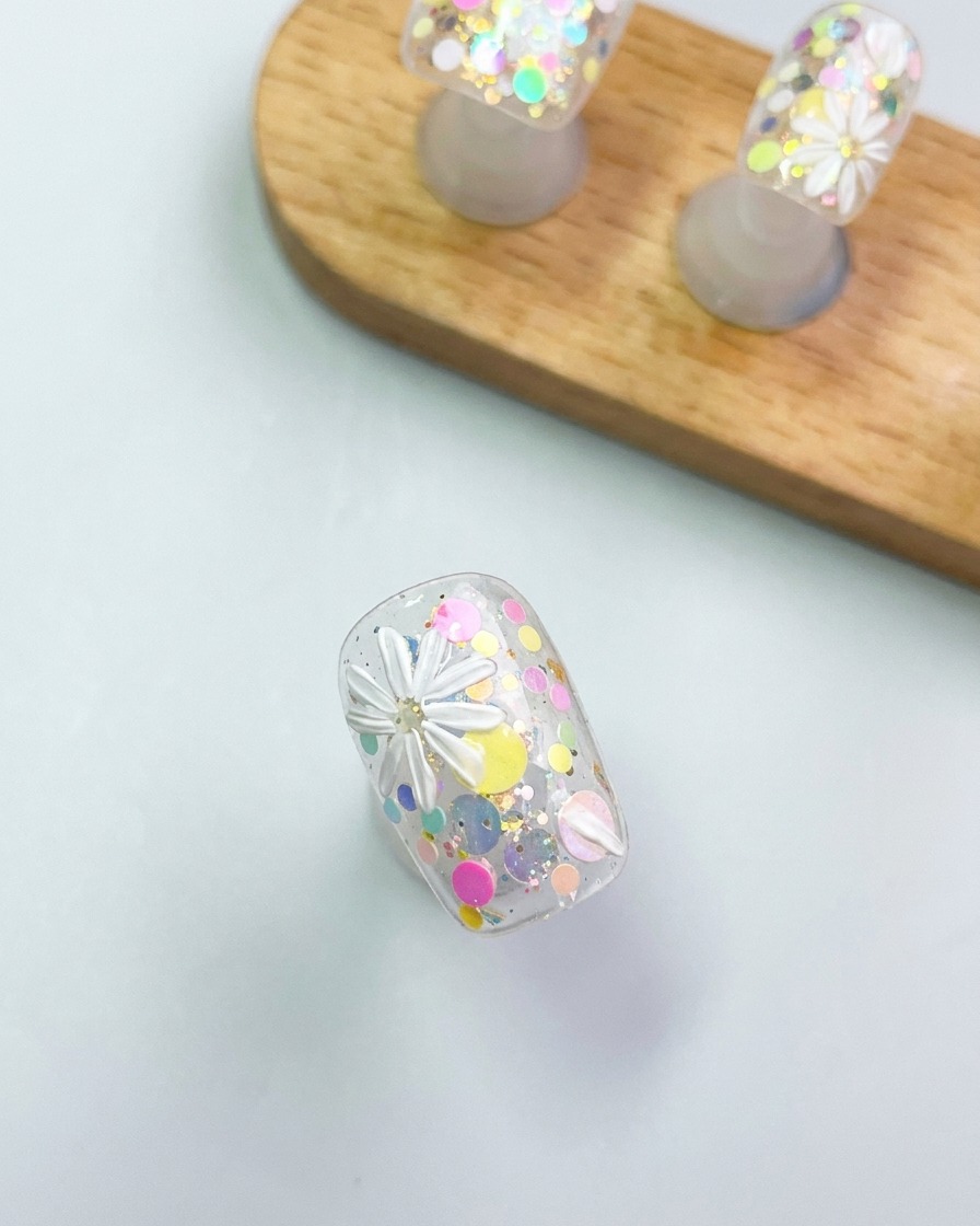 A close-up of a brush tool refining the delicate white petals of a 3D gel daisy.