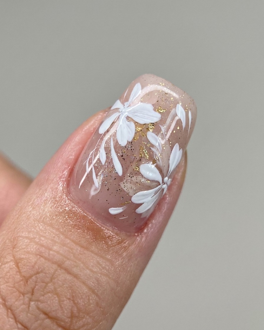 A brush applying a diagonal stripe of milky white gel polish onto a nail.