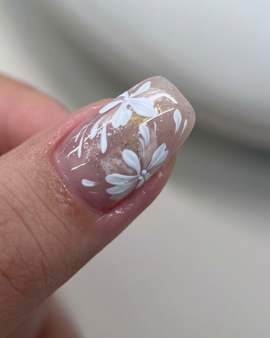 A thin layer of fine gold glitter being applied over a nail with gold foil.