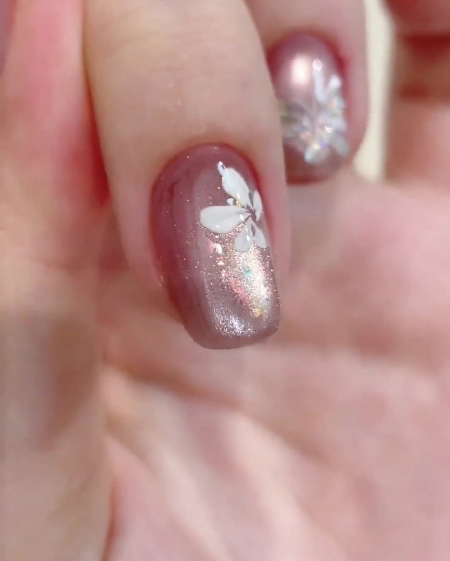 A close-up view of a hand inside a professional UV/LED nail lamp, with the nails illuminated by the curing light.