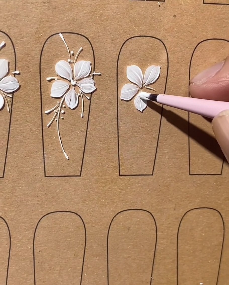 A flat brush finishing the fifth and final white gel petal to complete the flower shape.
