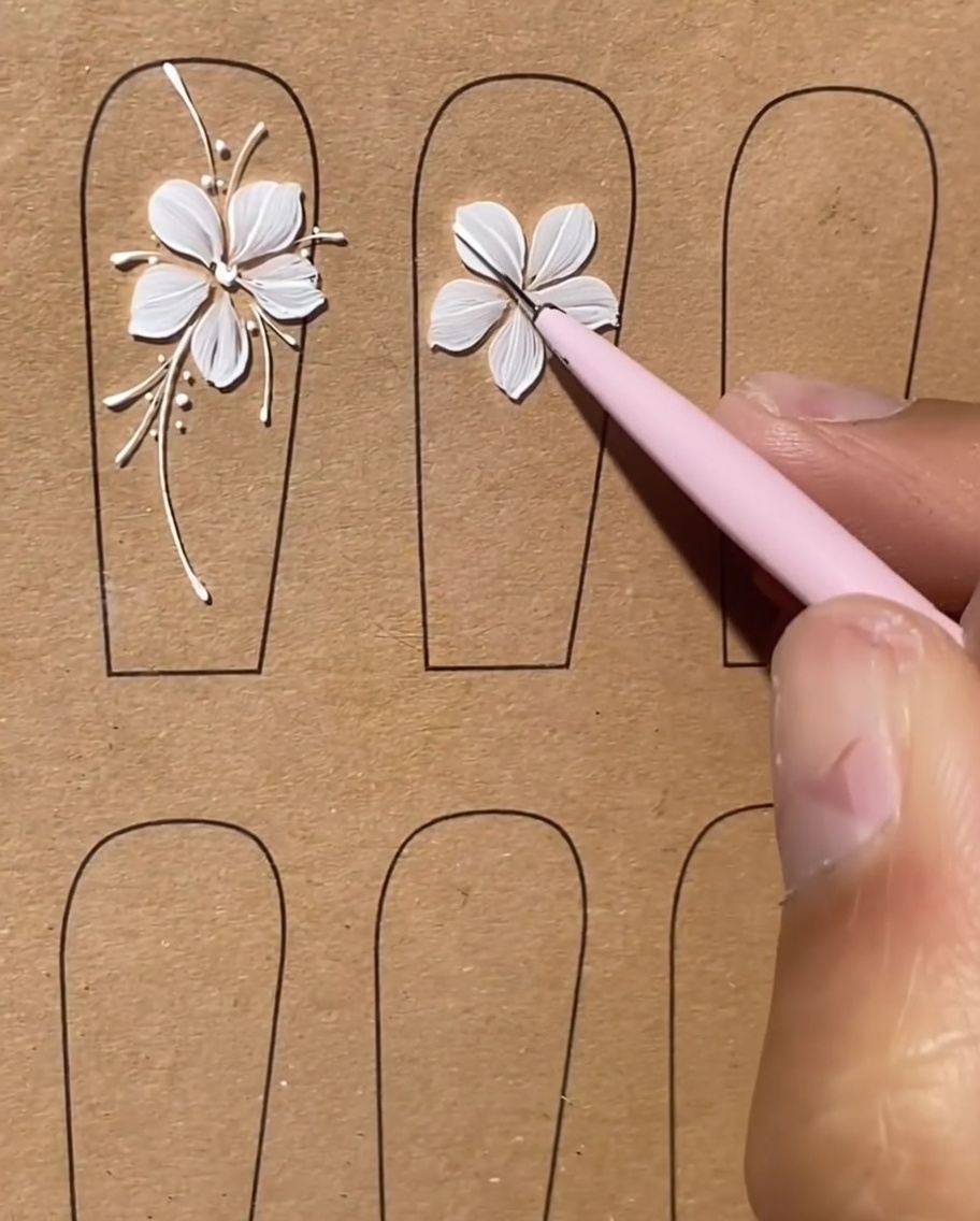 A nail with a white floral design featuring long, thin white lines extending outward like stems.