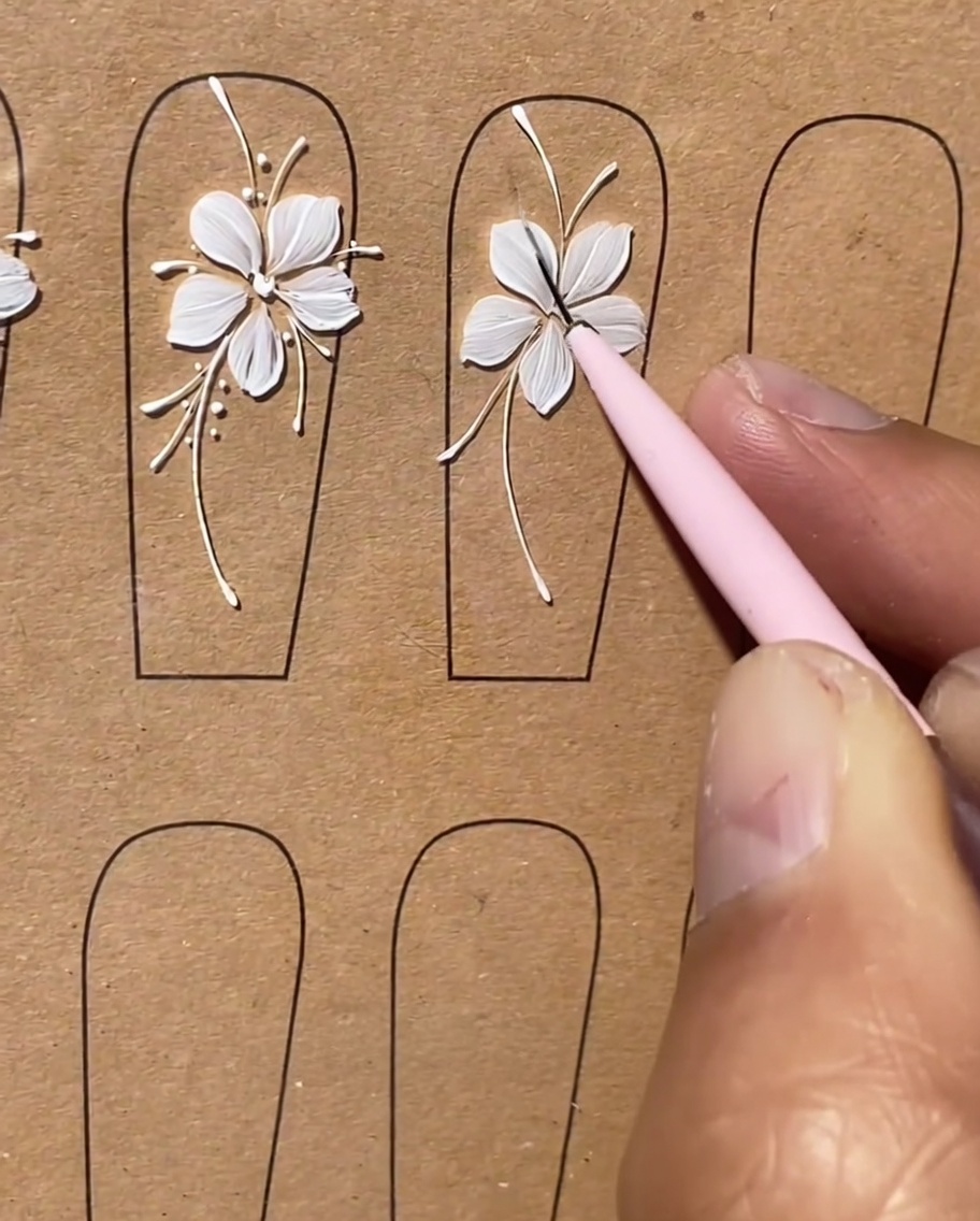 A brush adding tiny, short white lines as accents along the previously drawn curved stems.