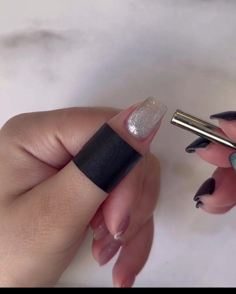 A hand resting inside a professional UV/LED nail lamp to cure the final top coat application.