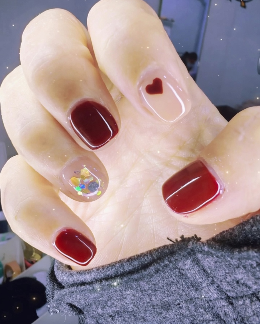 A lint-free wipe being used to clean the surface of a finished, glossy nail.