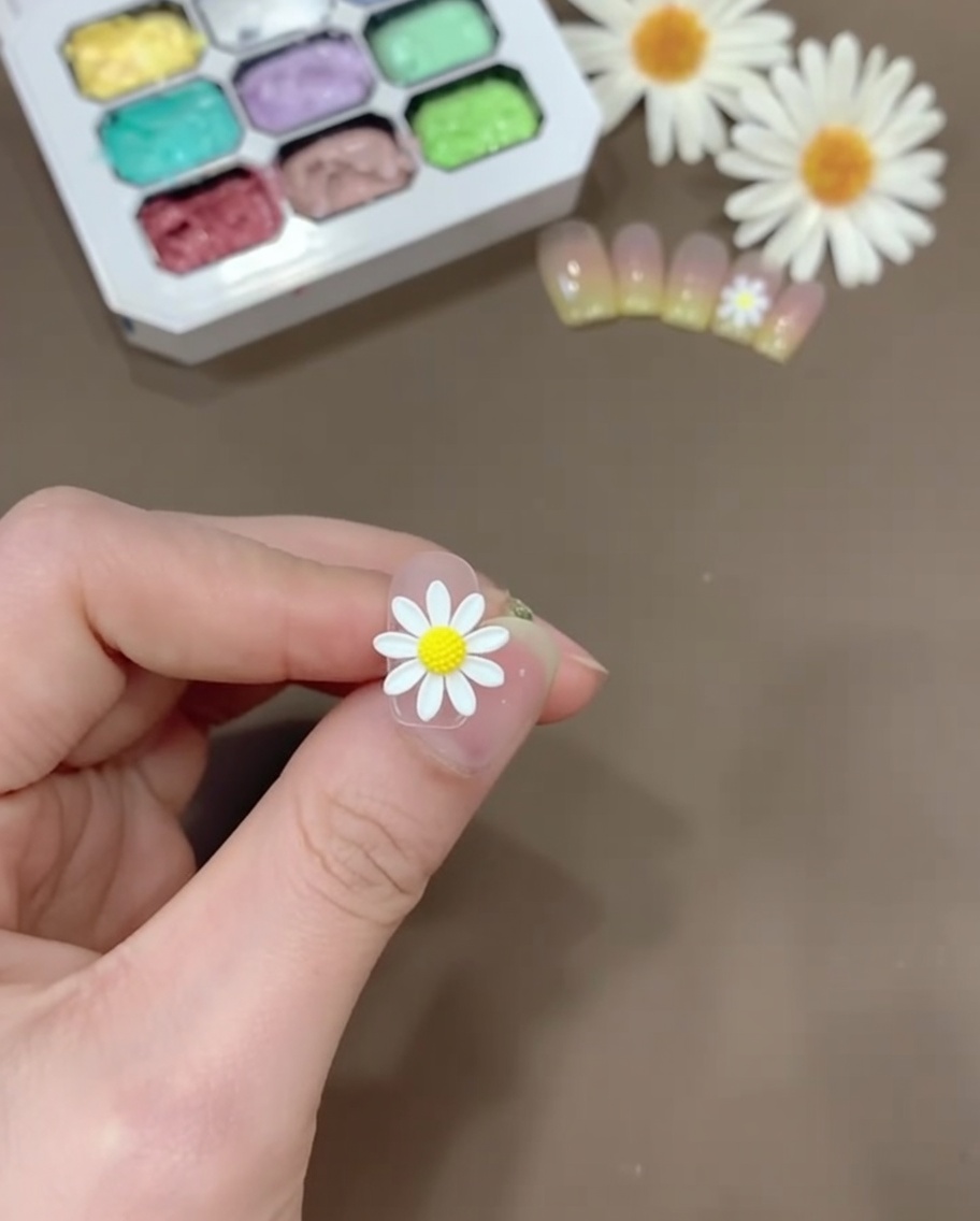 A small amount of yellow gel mixed with clear base coat on a plastic palette.