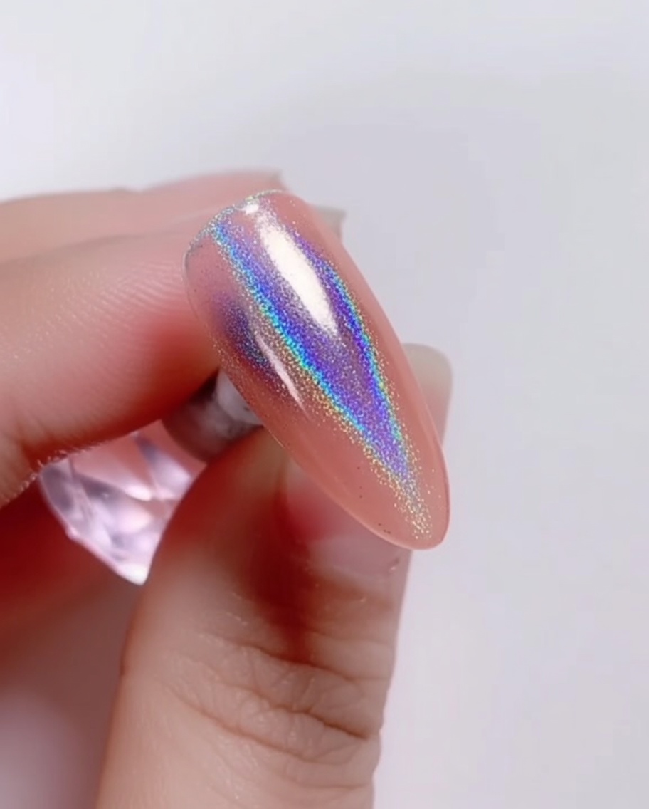 A brush applying a clear, glossy top coat over the iridescent laser powder on the nail.