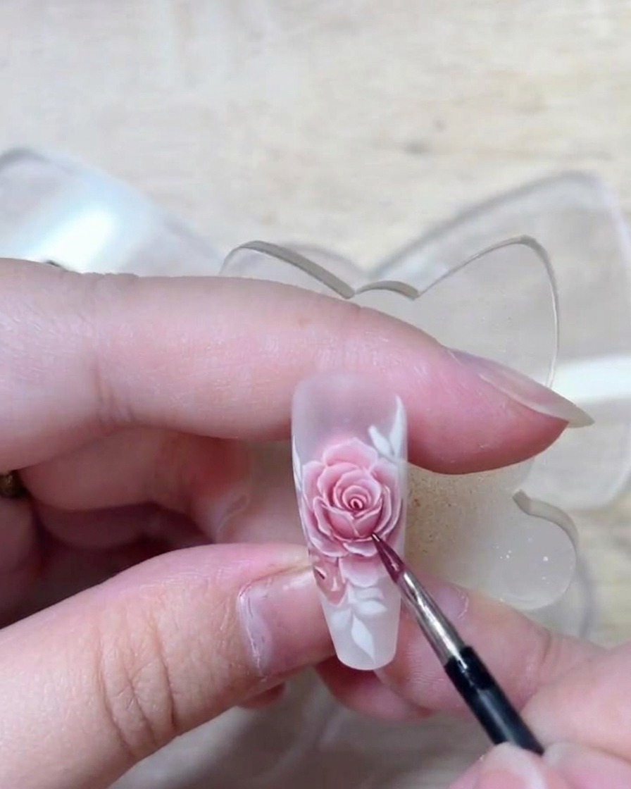 A close-up of the nail showing all rose bodies filled with a light red, with visible transitions and highlights.