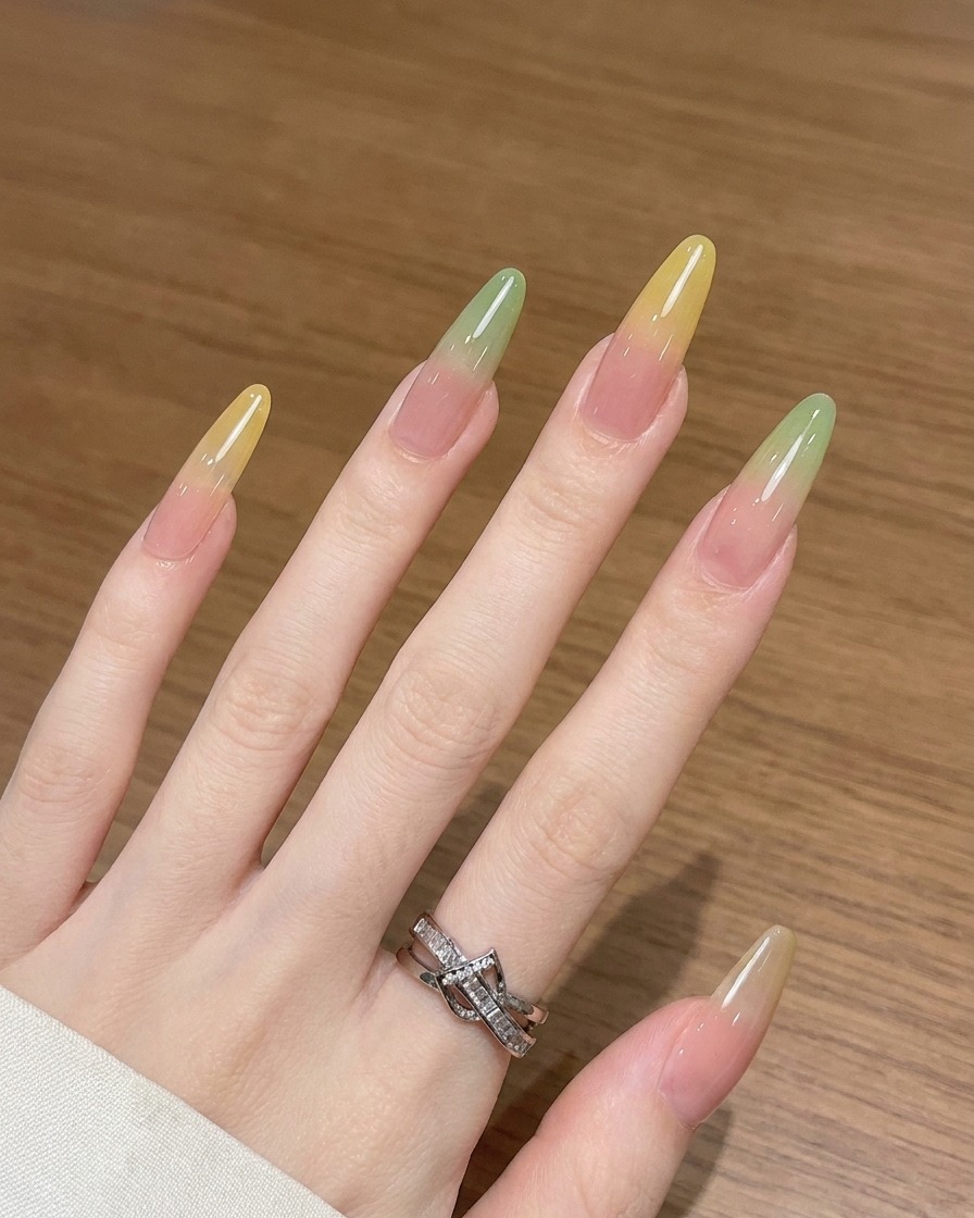 A close-up view showing an ombre brush blending yellow gel upwards on a nail.