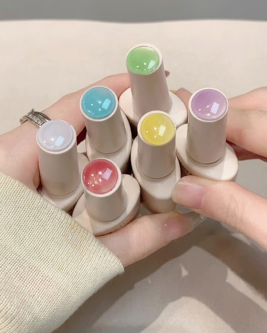 A nail brush applying a clear glossy top coat layer over finished nail art.