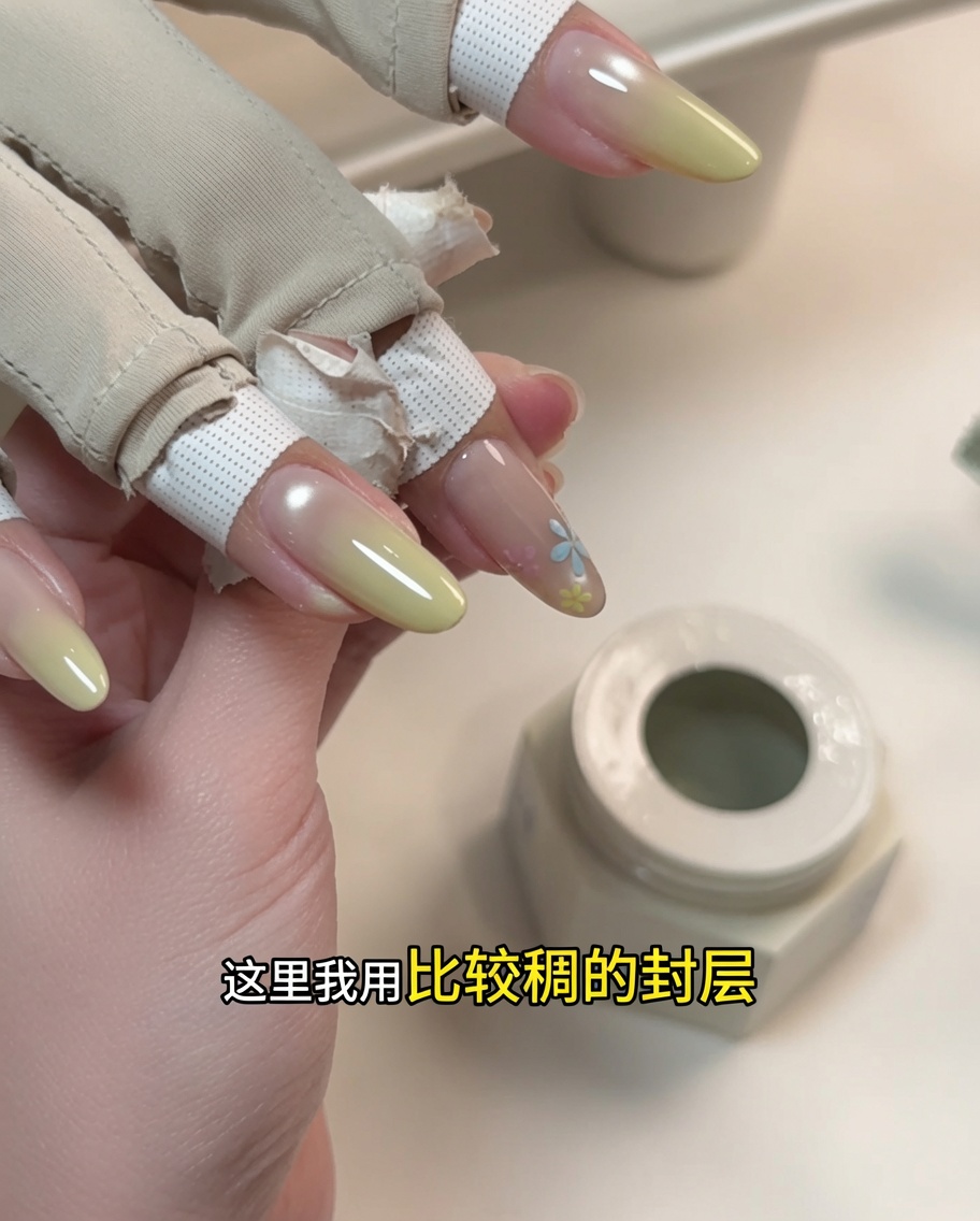 A close-up showing the application of a thick, sculpting gel over a painted floral design.