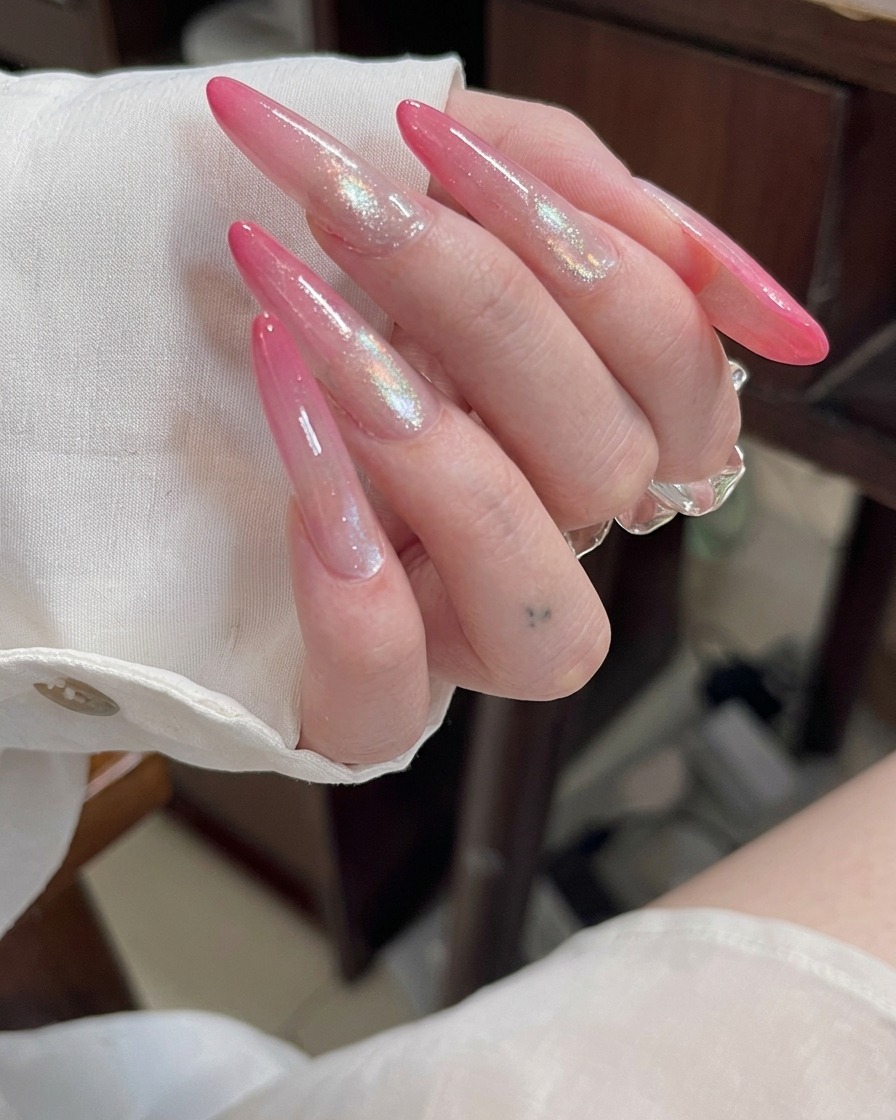 A view of long stiletto acrylic nails, showing the clear extension structure before any color is applied.