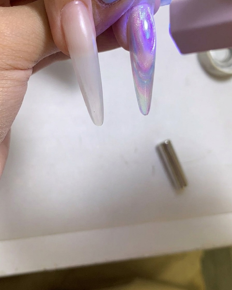 A portable UV/LED lamp curing a glossy cat eye gel nail.