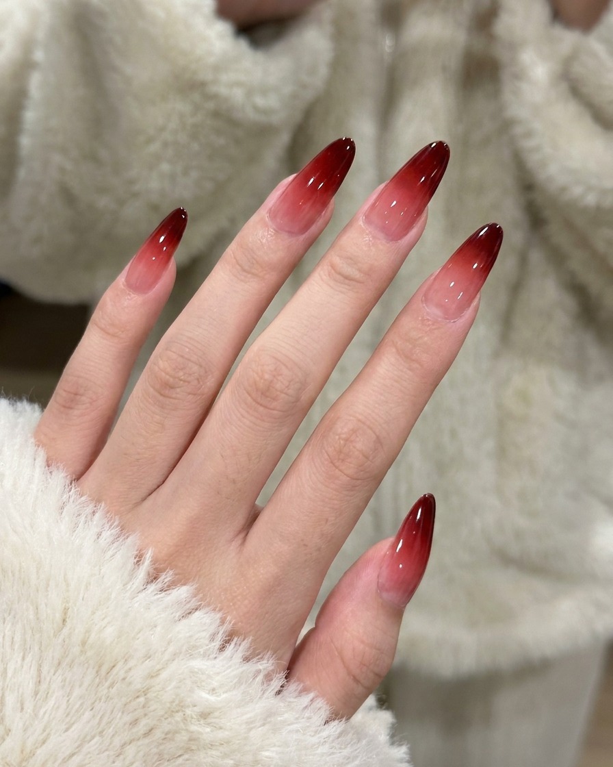 The second application of red gel being patted onto the nail to deepen the gradient color.