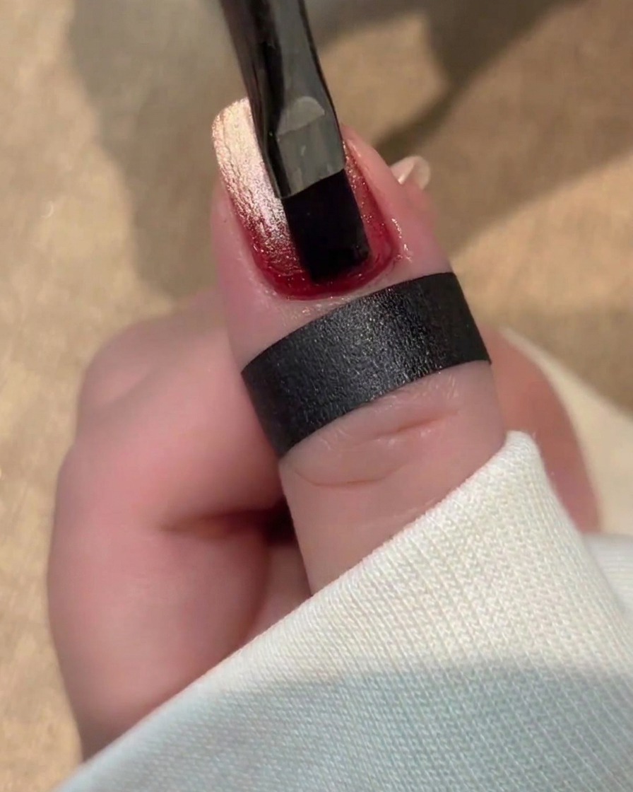 A thick, clear gel being applied to the nail surface, maintaining its shape without flowing.