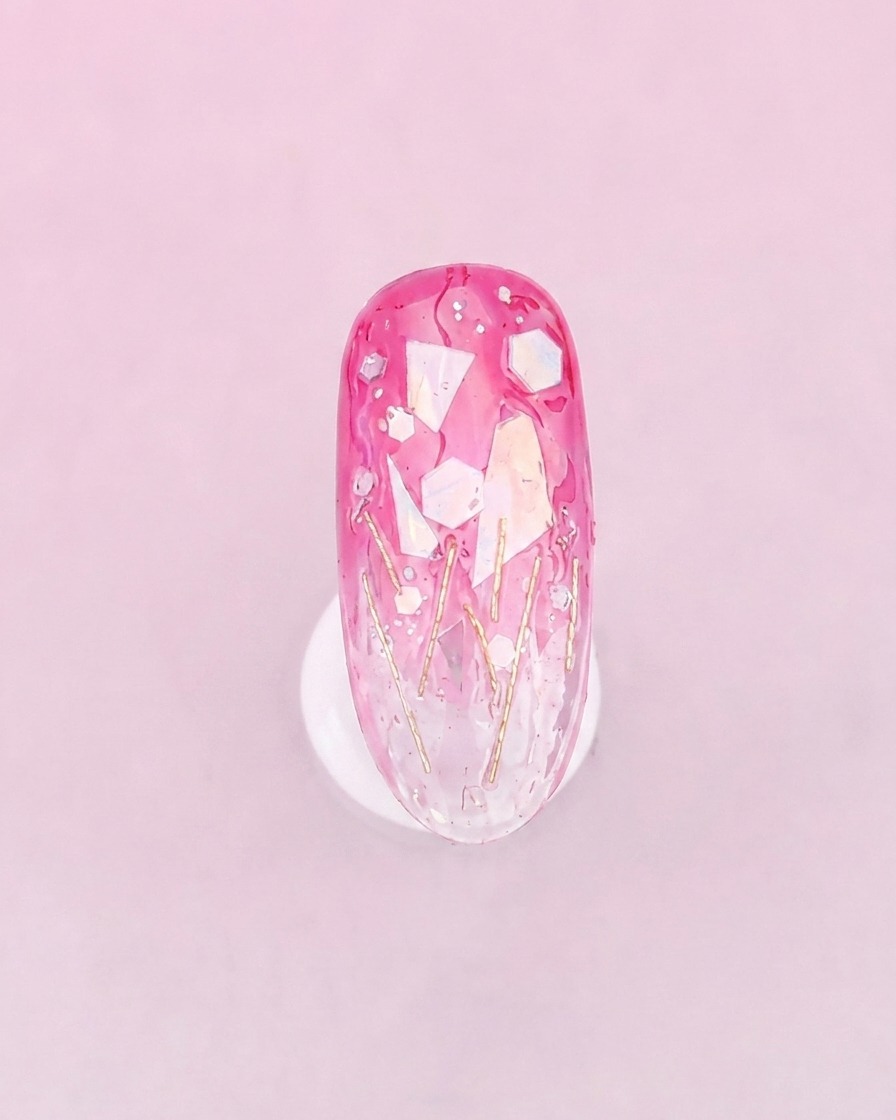 A brush applying a thicker, clear layer of glue over the decorated nail surface to smooth out the texture.