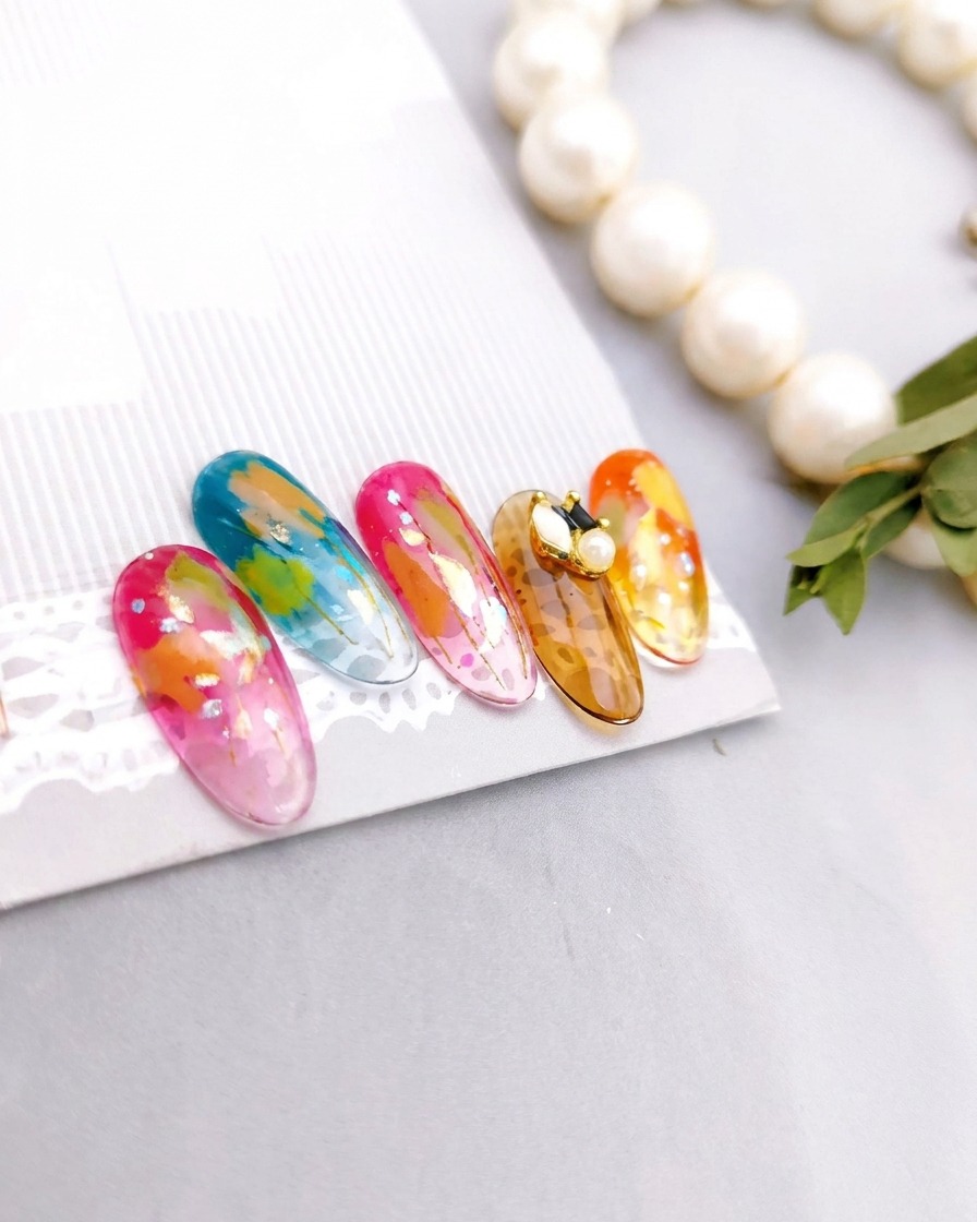 A set of five finished nails, each featuring unique artistic designs, resting on a display stand after being fully cured.