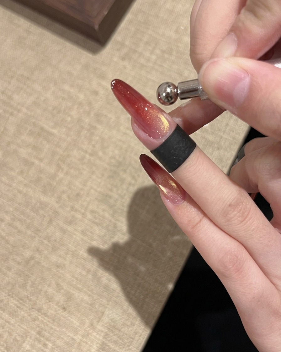 A ring magnet tool used to shape a bright, concentrated glass bead cat eye reflection on the nail.