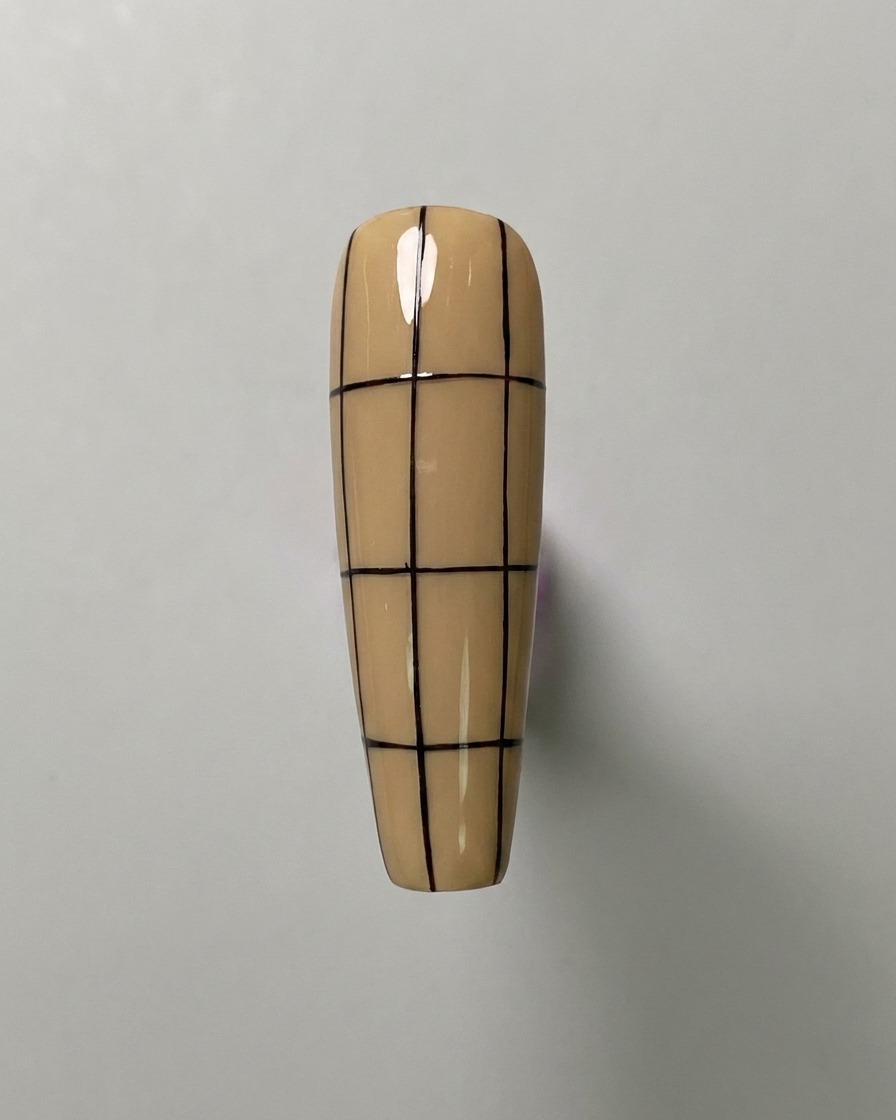 A nude-colored nail featuring three vertical lines and three evenly spaced horizontal lines, creating a large grid pattern.