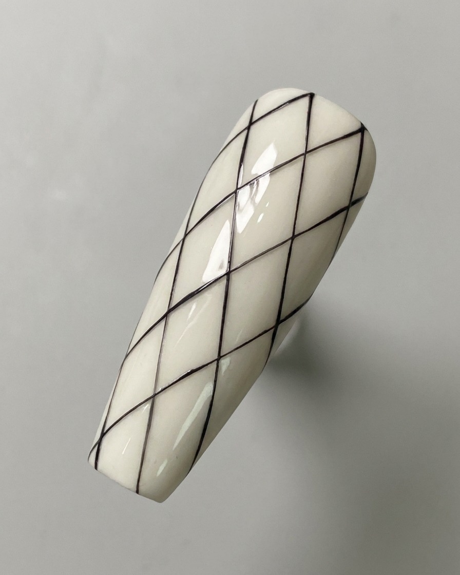 A fully drawn black diamond grid pattern on a white base nail surface.