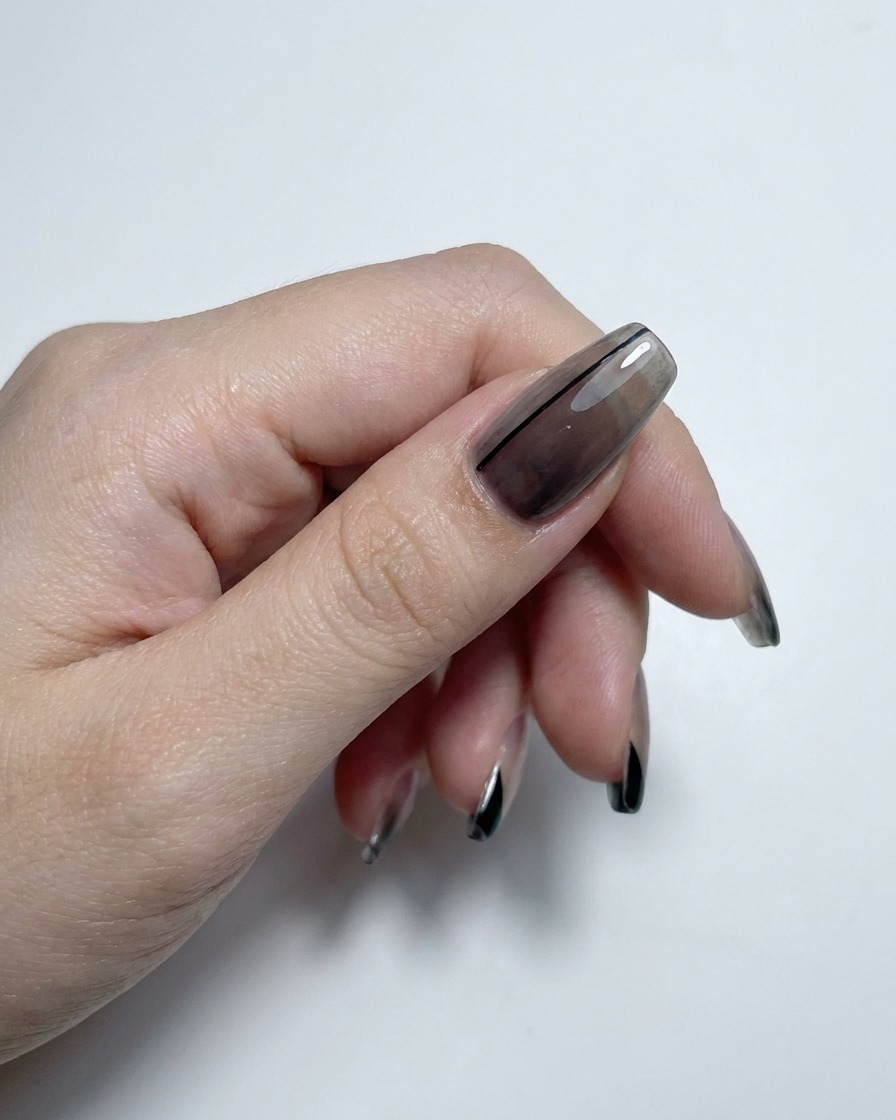 A hand showing translucent gradient and french-tipped nails finished with a high-gloss top coat.