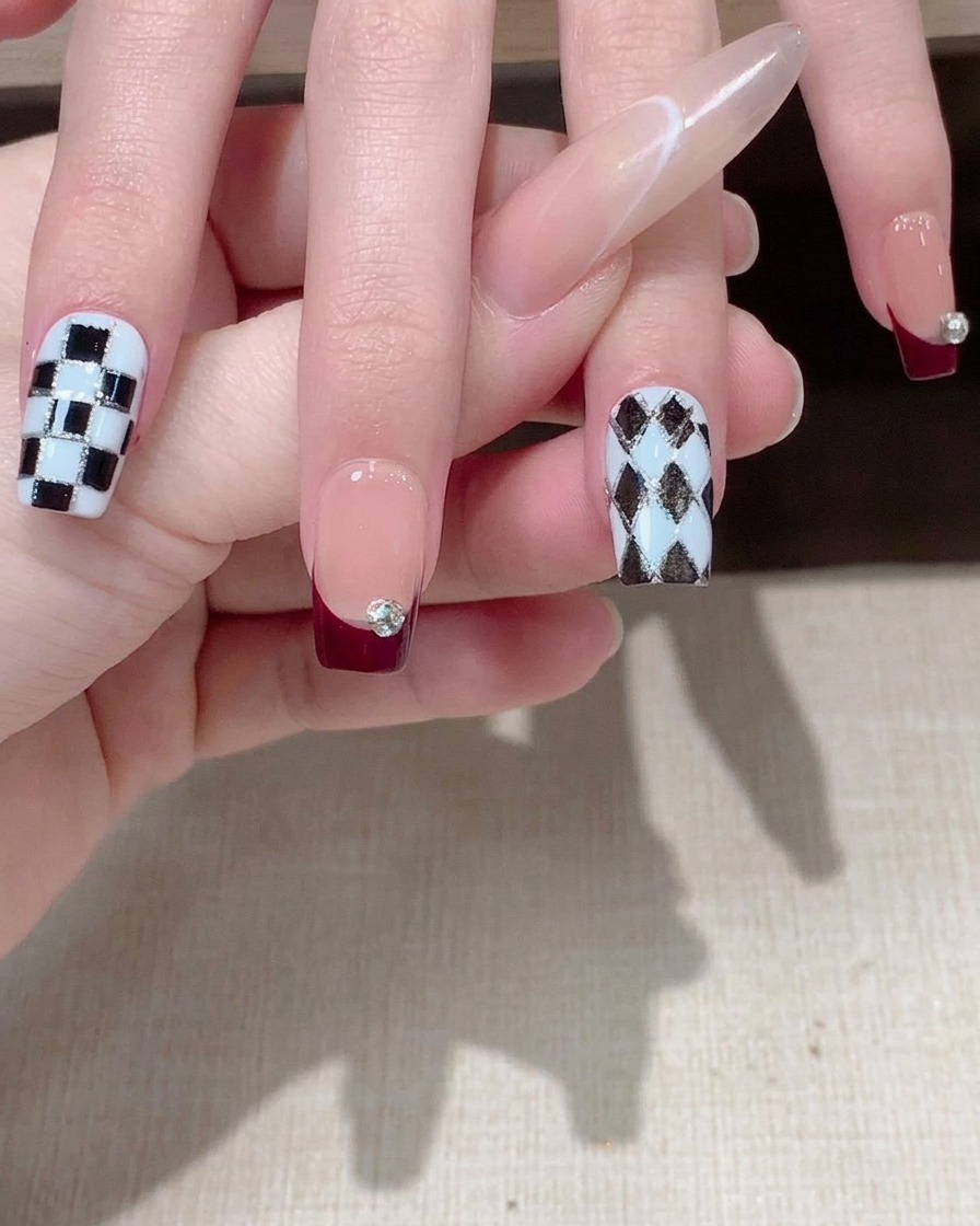 A close-up of a finger with a geometric line sticker smoothed over the nail.