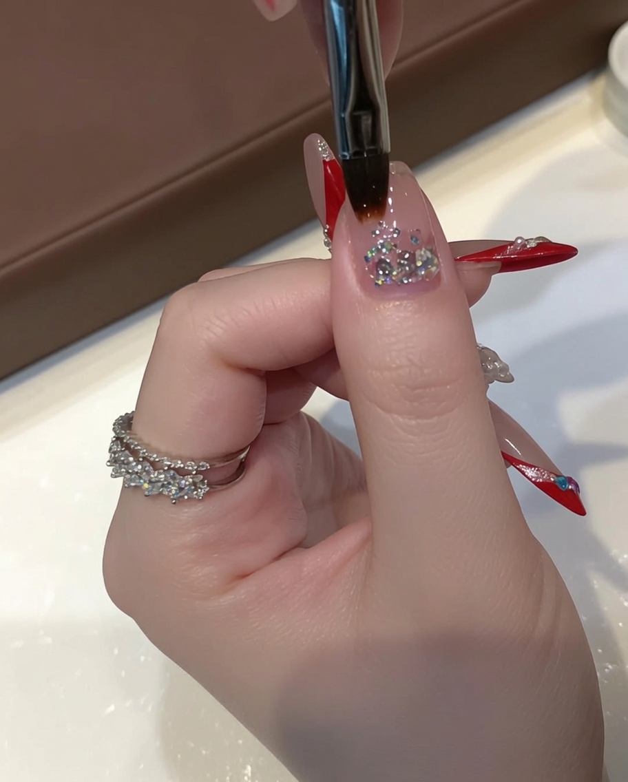 A detailing brush gently pulling chunky sequin gel down the center of the nail to create a fading gradient.