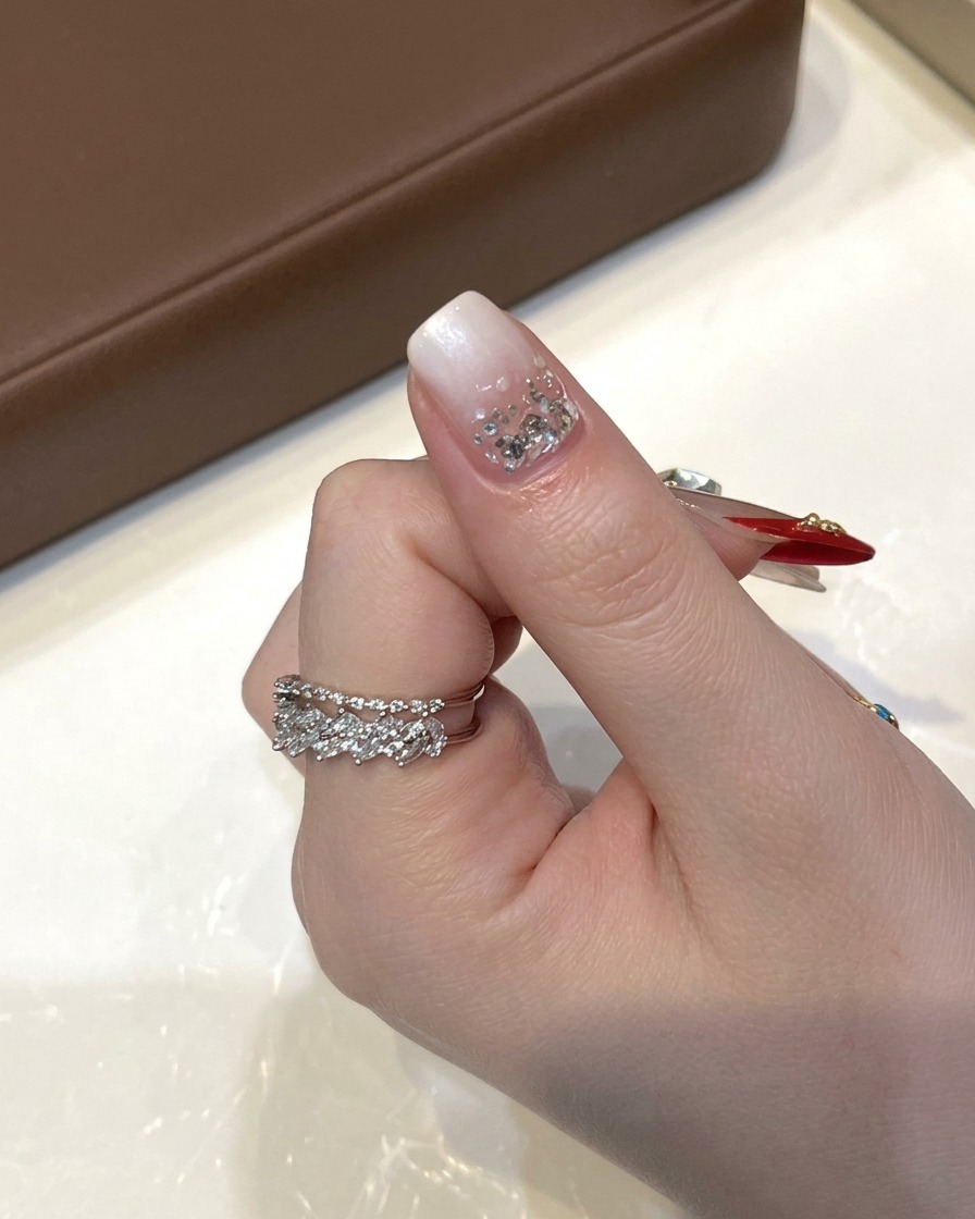 A mini green UV LED curing lamp positioned directly over a fingernail to cure gel polish.