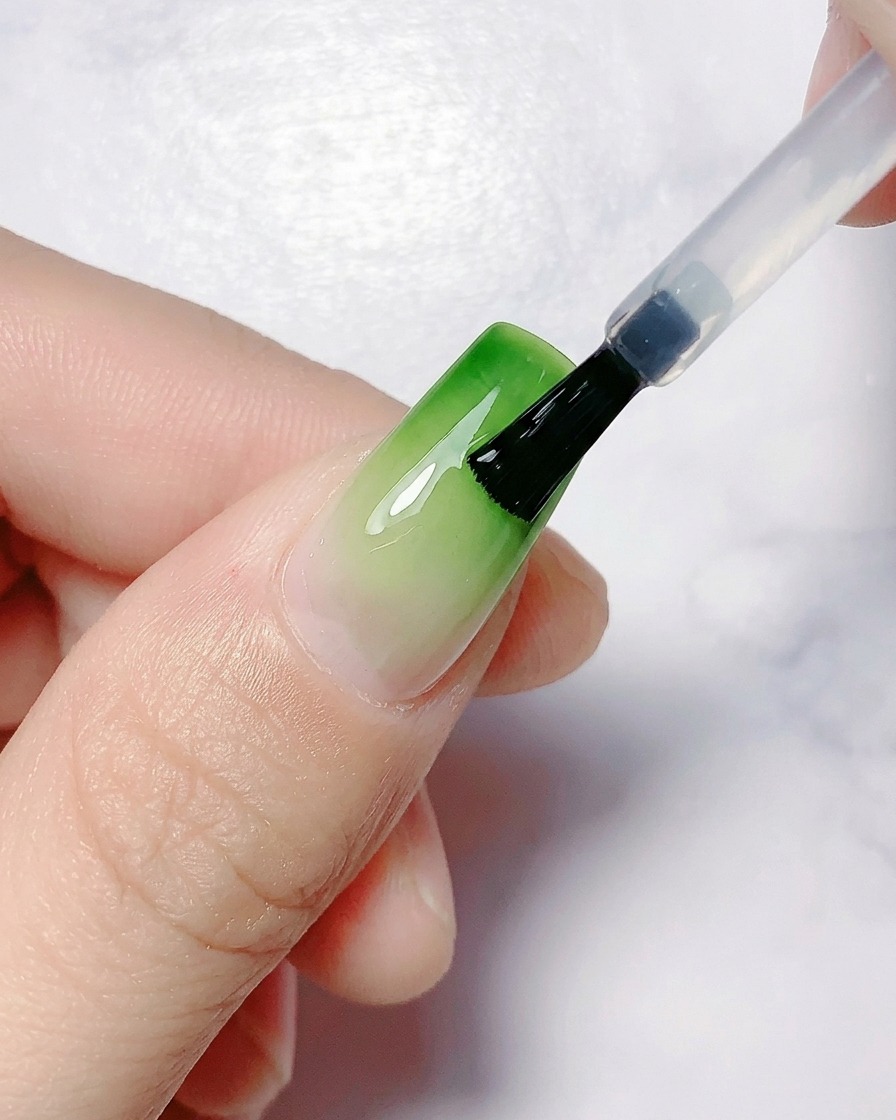 A hand positioned under a UV/LED nail lamp for curing.