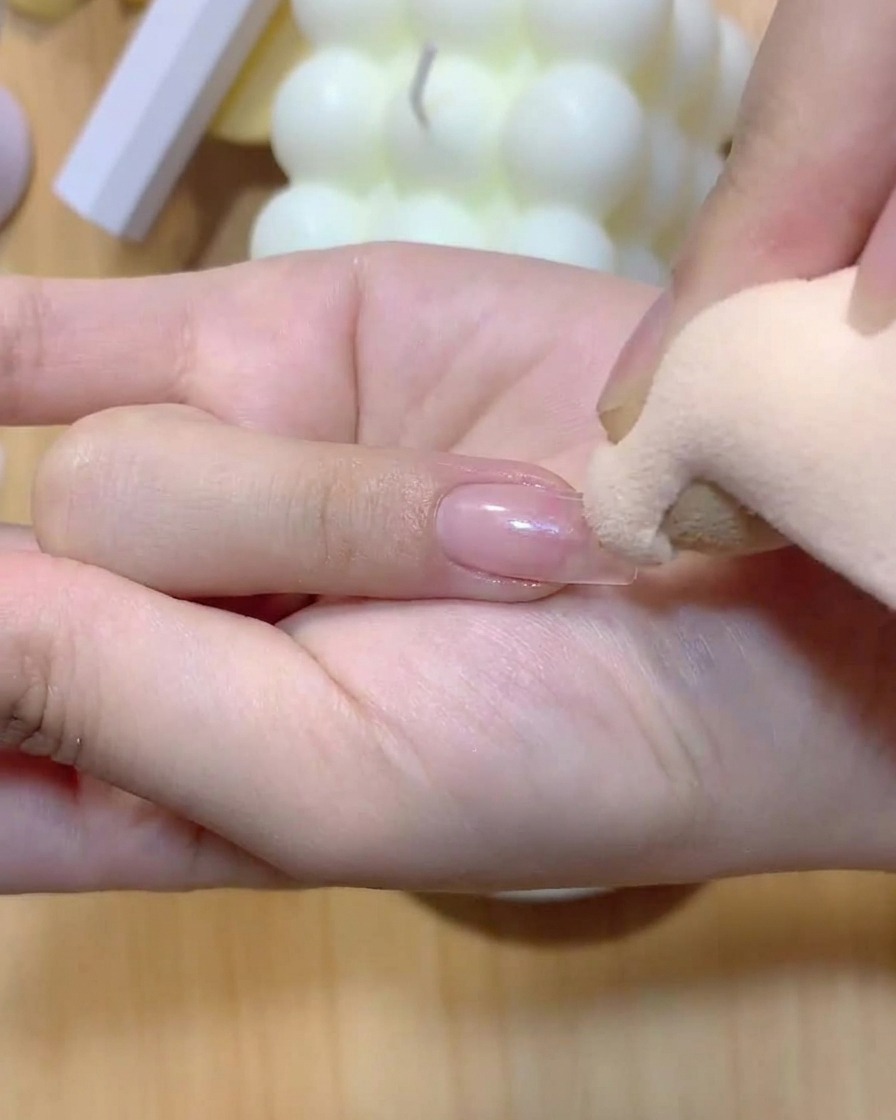 A makeup sponge gently dabbing color onto a fingernail to create an ombre gradient.