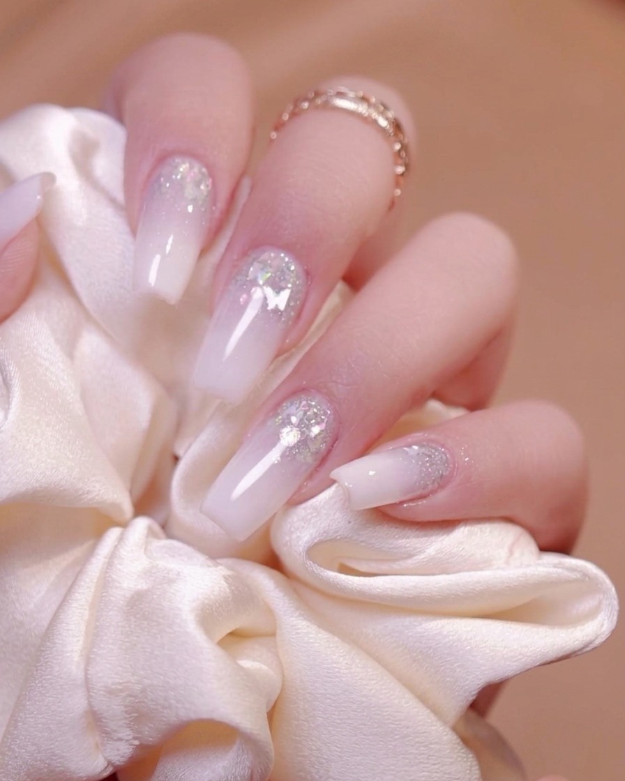 An electric nail drill filing and smoothing the surface of a manicured nail.