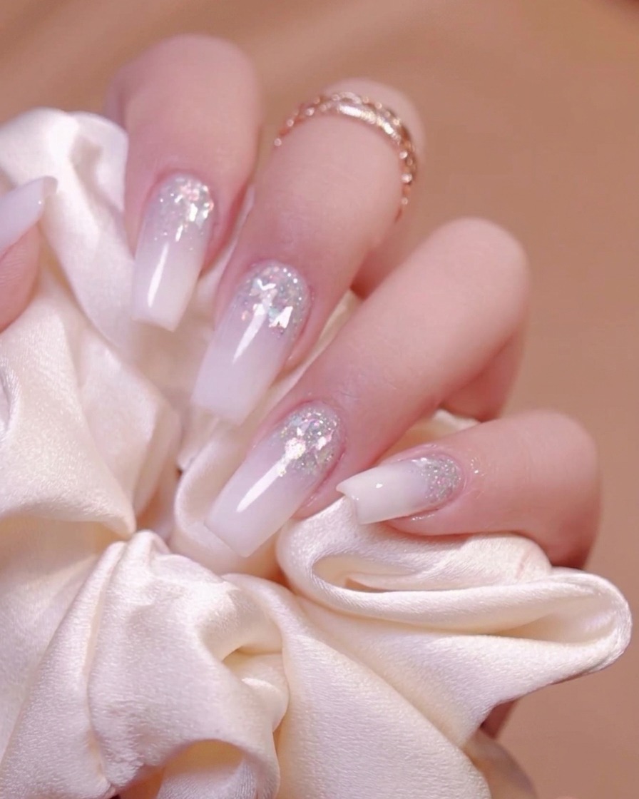 A hard manicure brush sweeping dust away from the nail grooves.